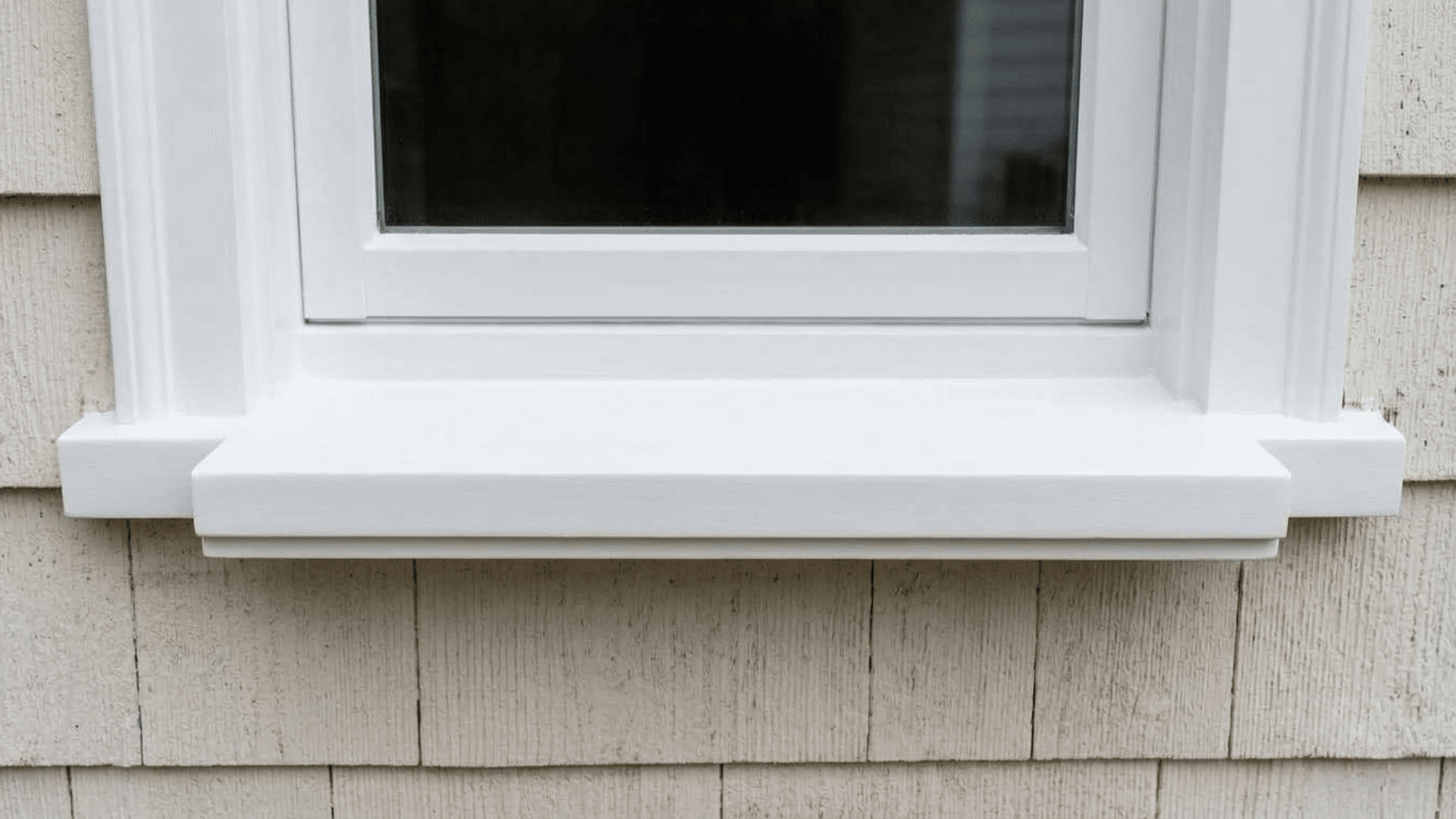 Finished white window sill replacement with a clean painted surface and updated window frame.